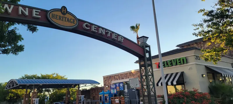 Heritage Towne Center arch ending at a lattice tower beside the 7-Eleven storefront in Otay Ranch