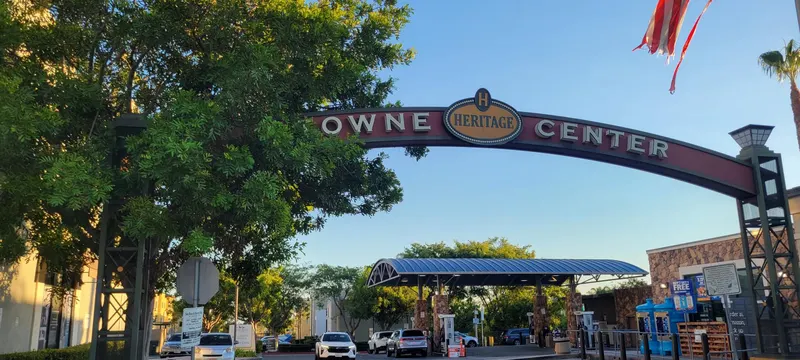 Heritage Towne Center arch framed by green trees above the parking area in Otay Ranch, Chula Vista
